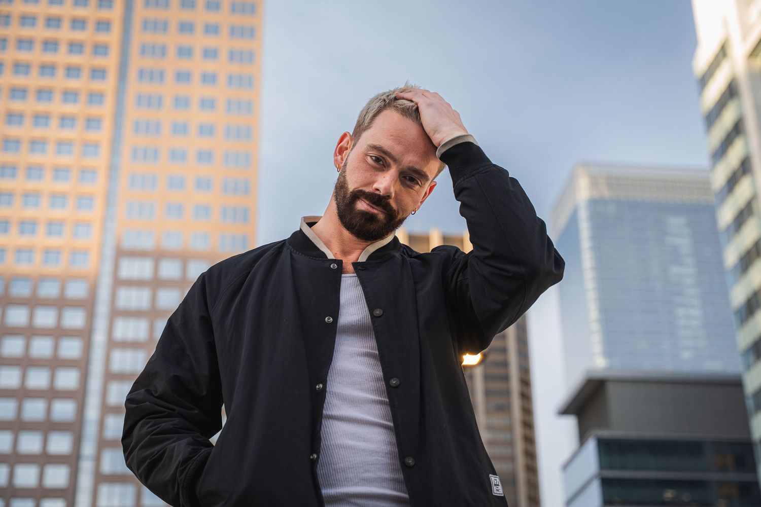 Urban fashion photoshoot with modern city buildings in background.