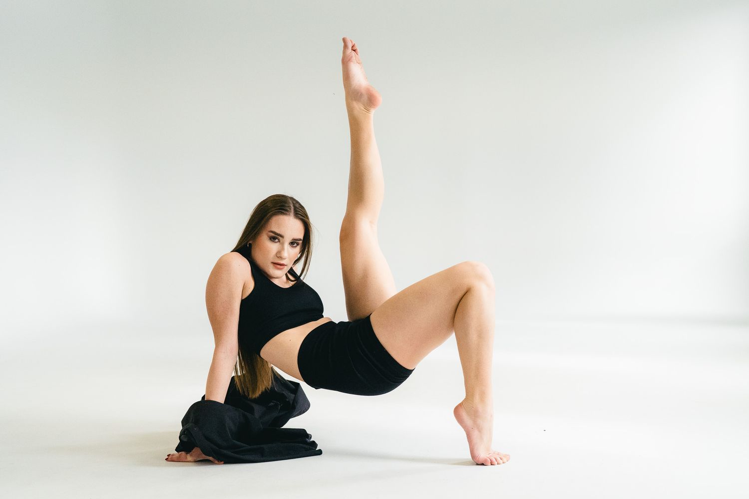 Artistic dance poses captured in minimalist white studio setting.