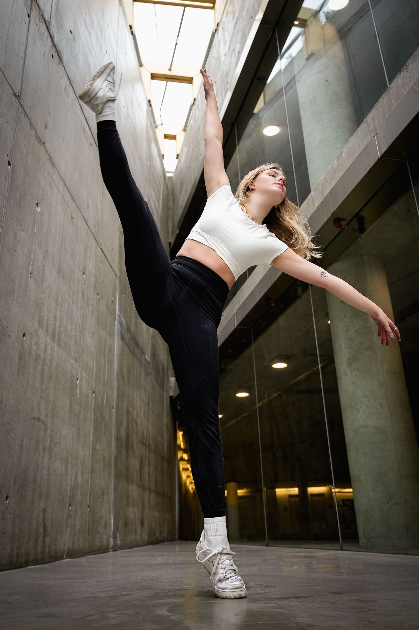 Dynamic dance sequence showing athletic movements in a concrete hallway.