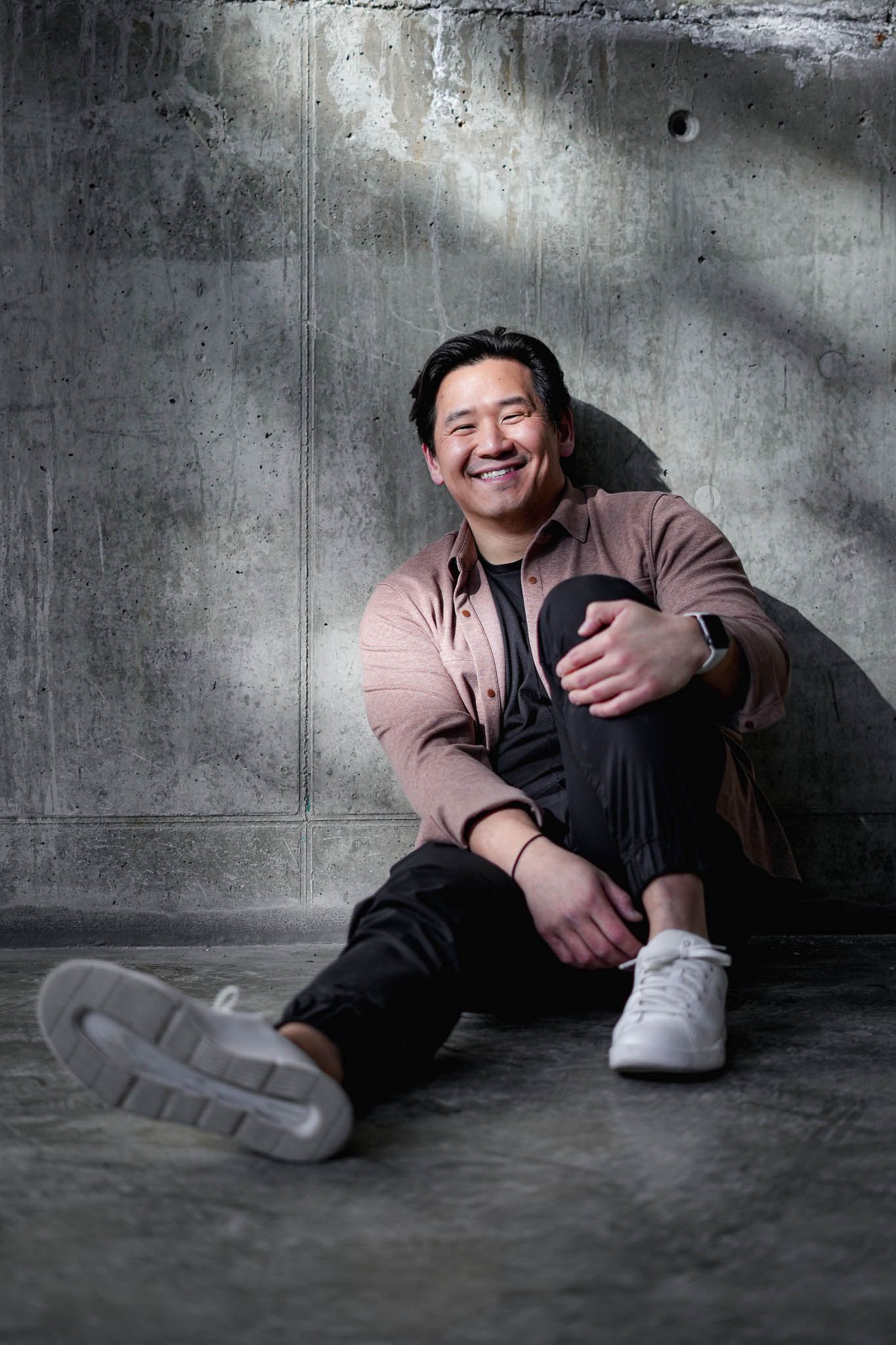 Floor-level portraits against industrial concrete background with dramatic lighting.