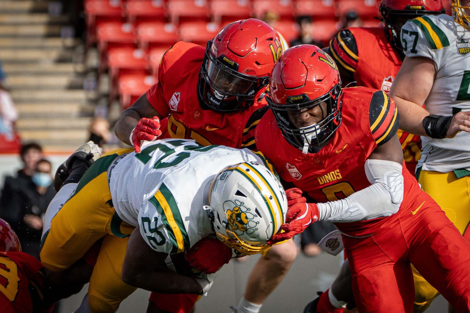 Close-up of football players colliding during competitive game play.