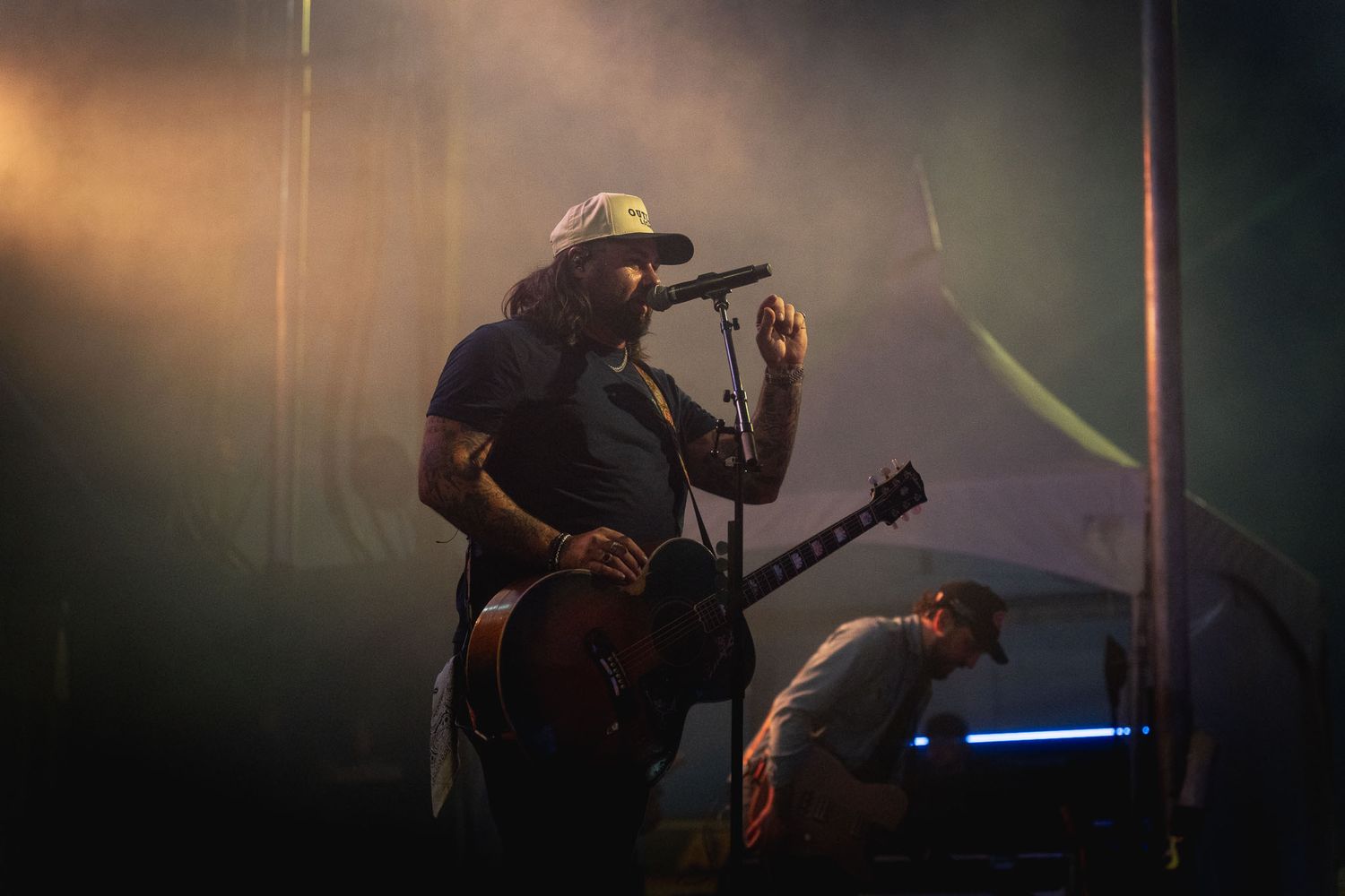 Silhouetted country band Koe Wetzel performing on a dimly lit concert stage.