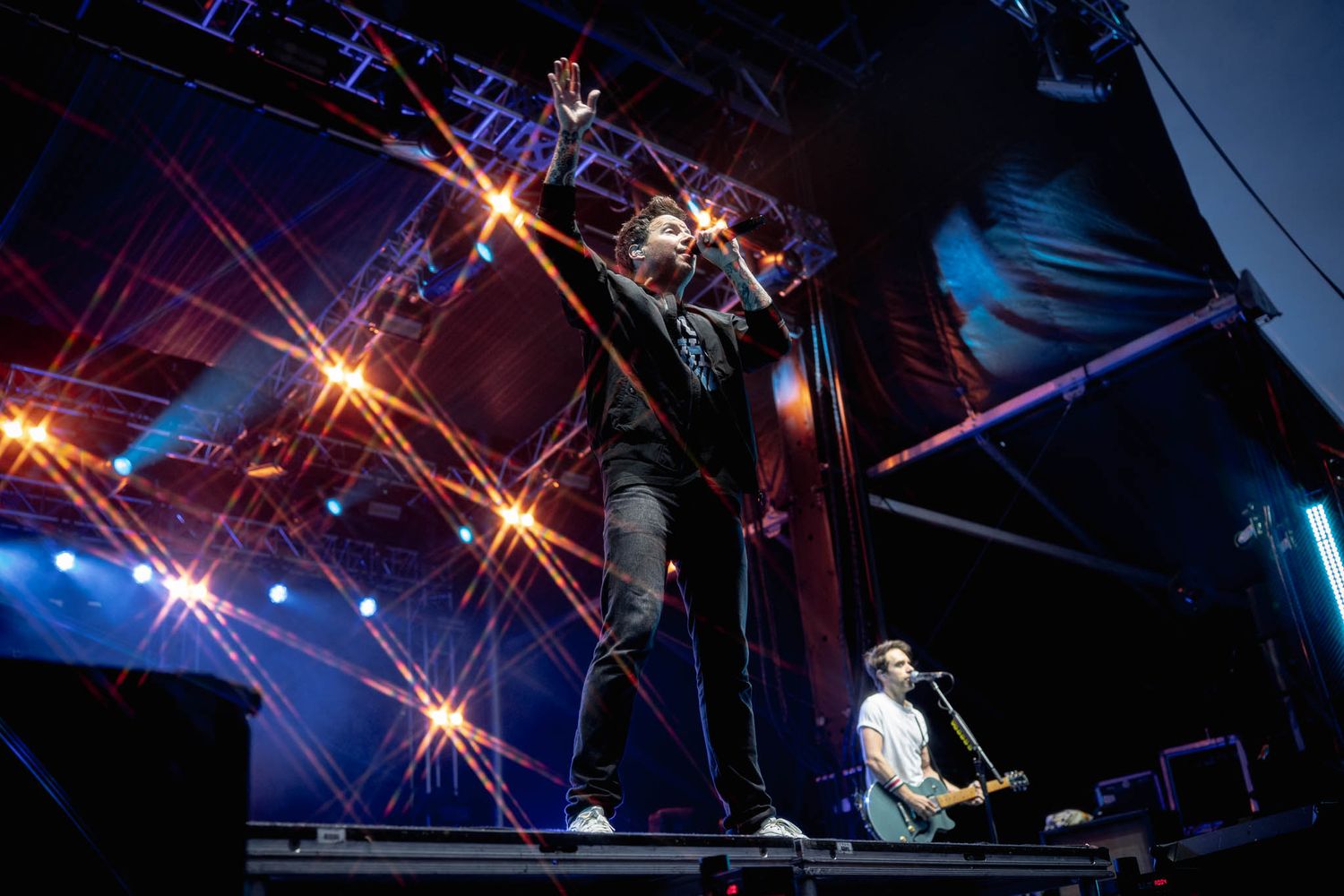 Concert stage illuminated with blue lighting and dramatic star burst effects.
