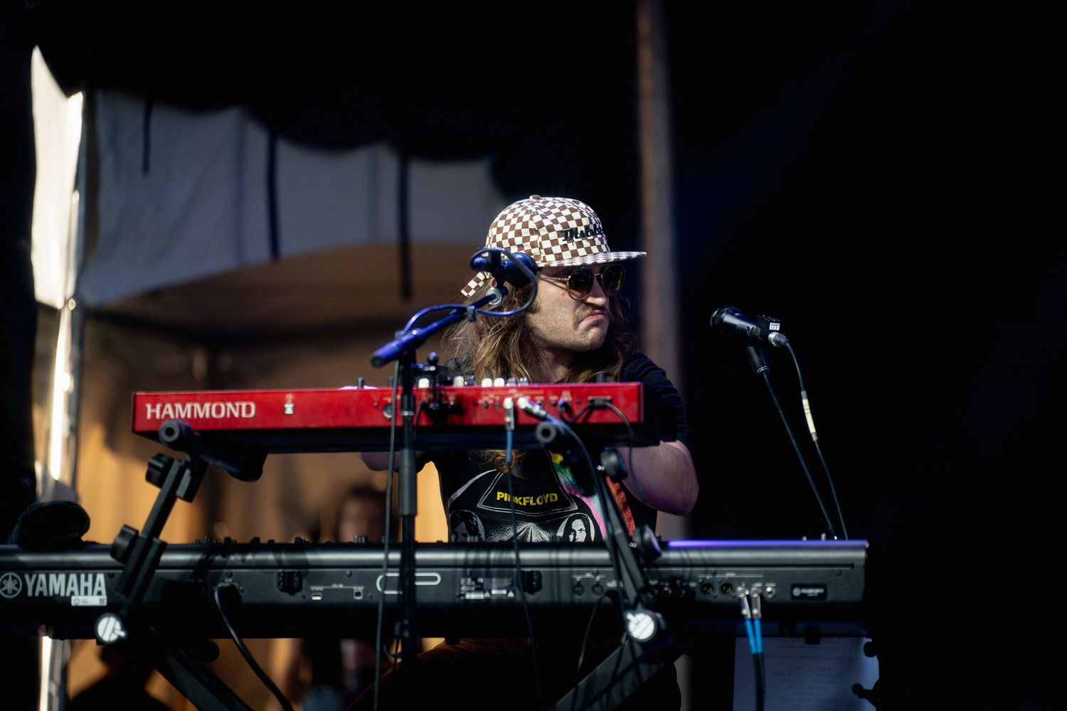 Keyboard setup on stage with electronic equipment and performance lighting.