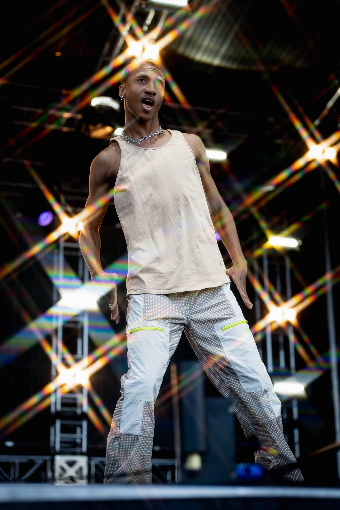 Dynamic stage performance with dancer in white tank top against dramatic star-shaped lighting.