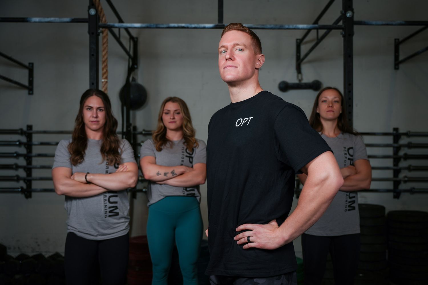 Group of fitness enthusiasts posing together in gym environment.
