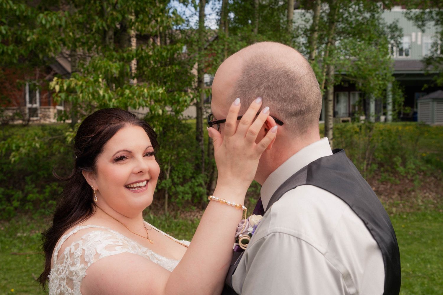 Newlyweds share loving moments in a garden setting with natural greenery.