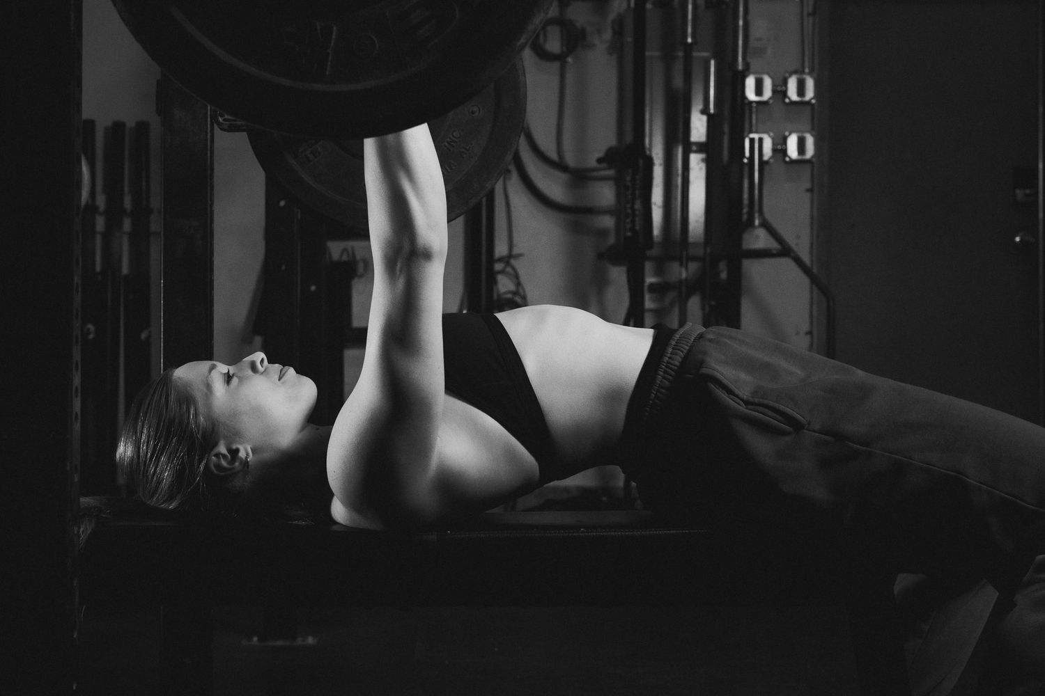 Low-angle view of fitness equipment silhouettes in a darkened gym setting.