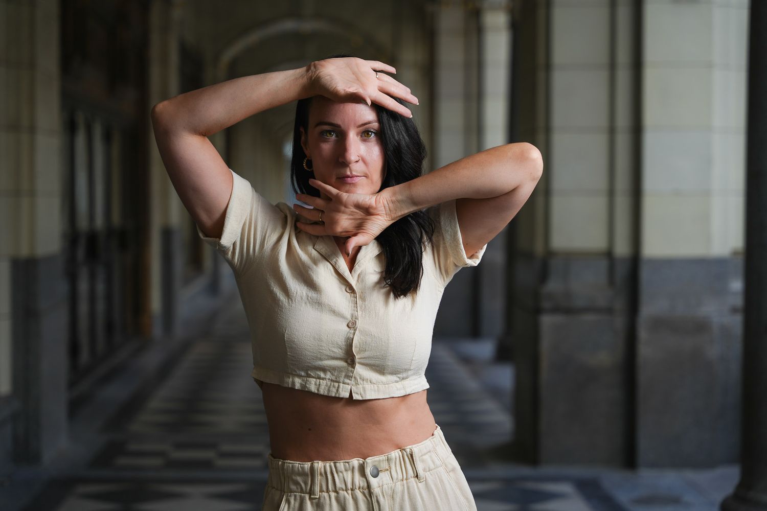 Modern dancer strikes dynamic poses in beige outfit against architectural backdrop.