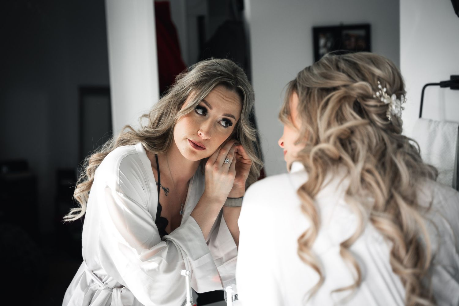 Getting ready scene with white robes and soft morning light in an intimate setting.