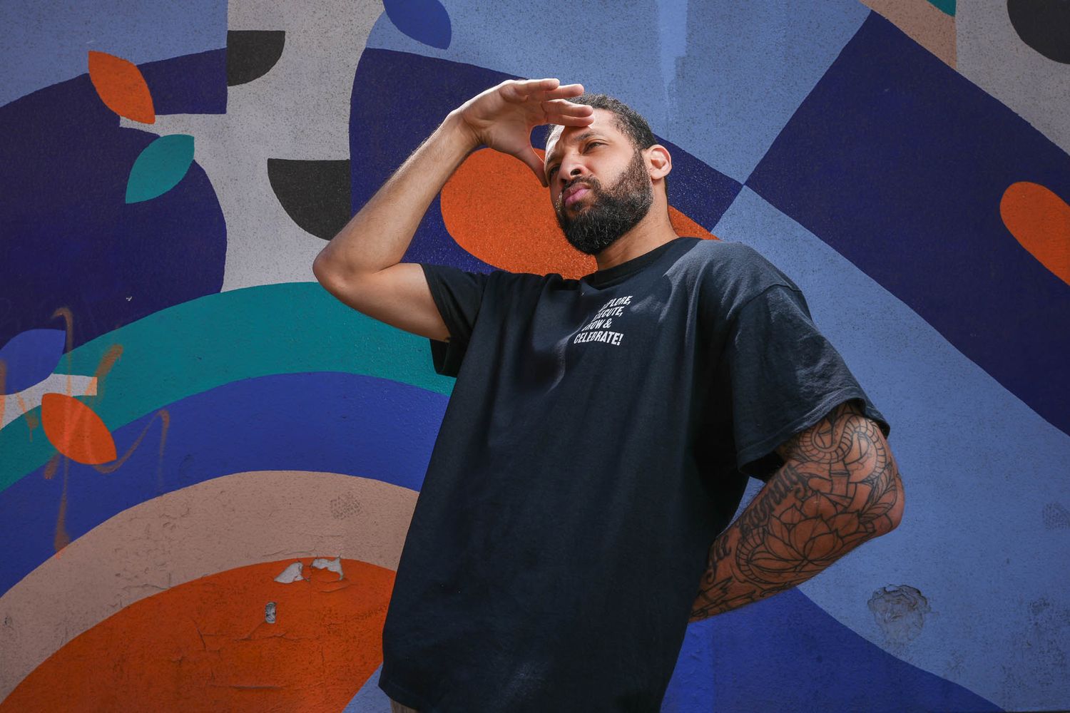 Abstract colorful mural with geometric shapes serves as backdrop for artistic portraits.