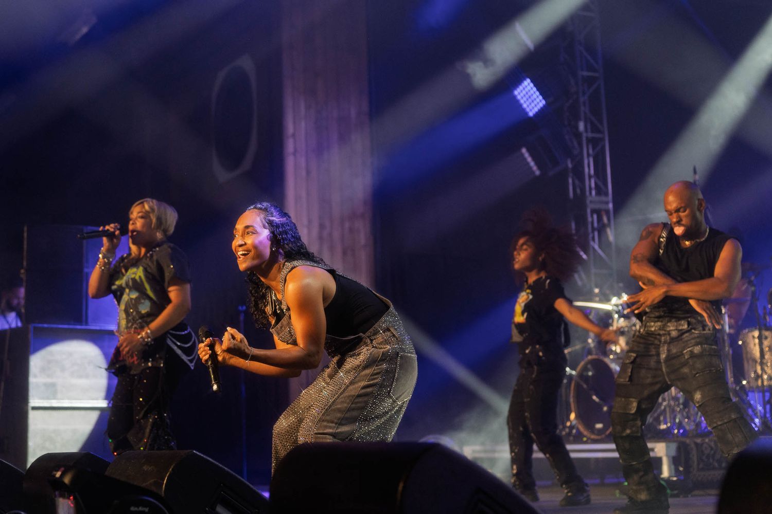 Concert performance with dynamic stage lighting showing silhouettes of musicians in action.