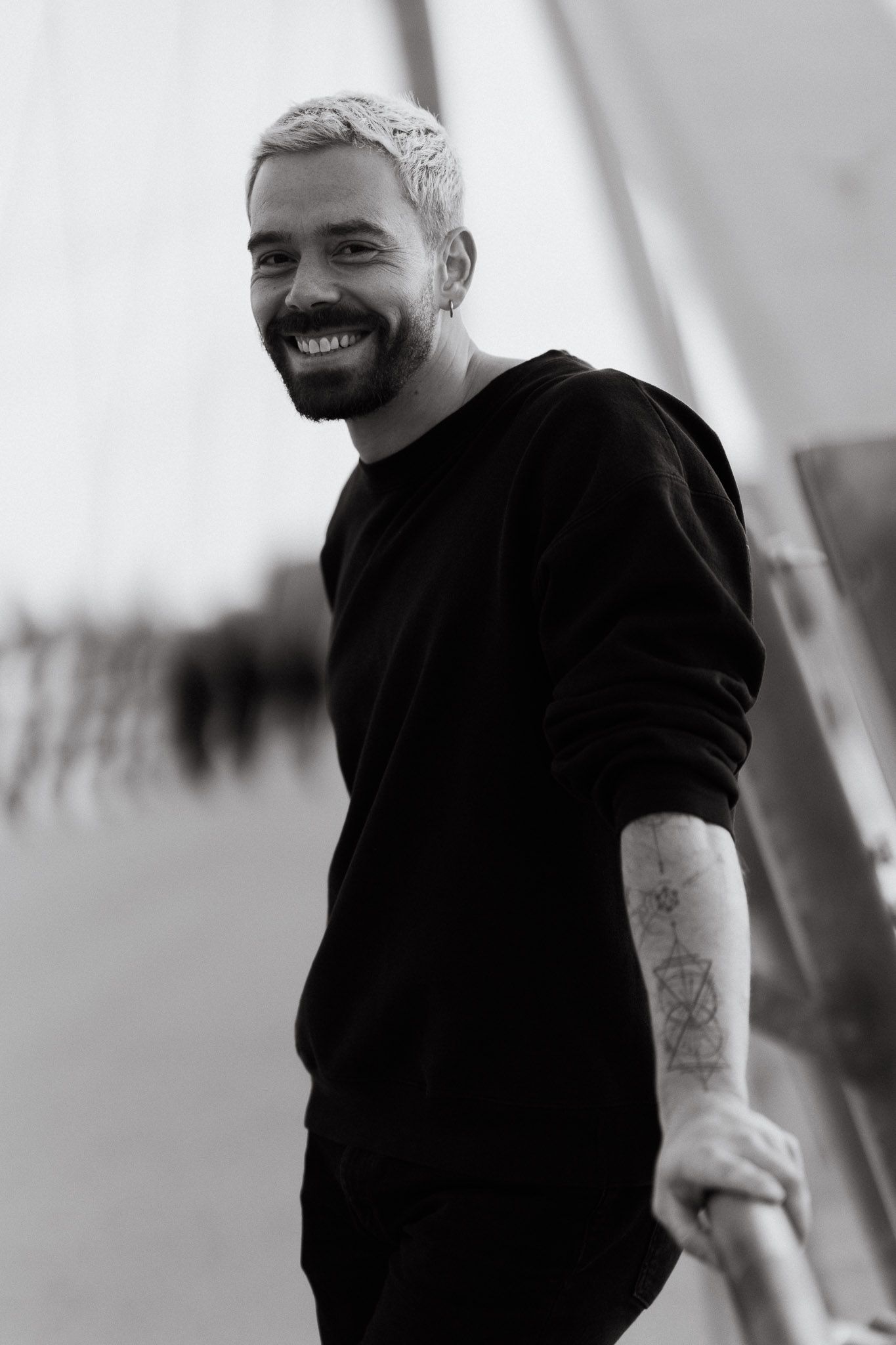 Black and white portrait series showing joyful expressions against light background.