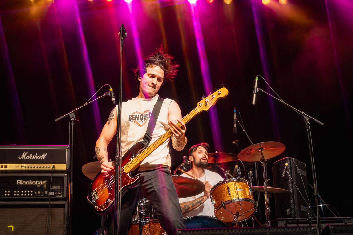 Rock band Mattstagraham performs under vibrant purple and pink stage lighting at concert venue.
