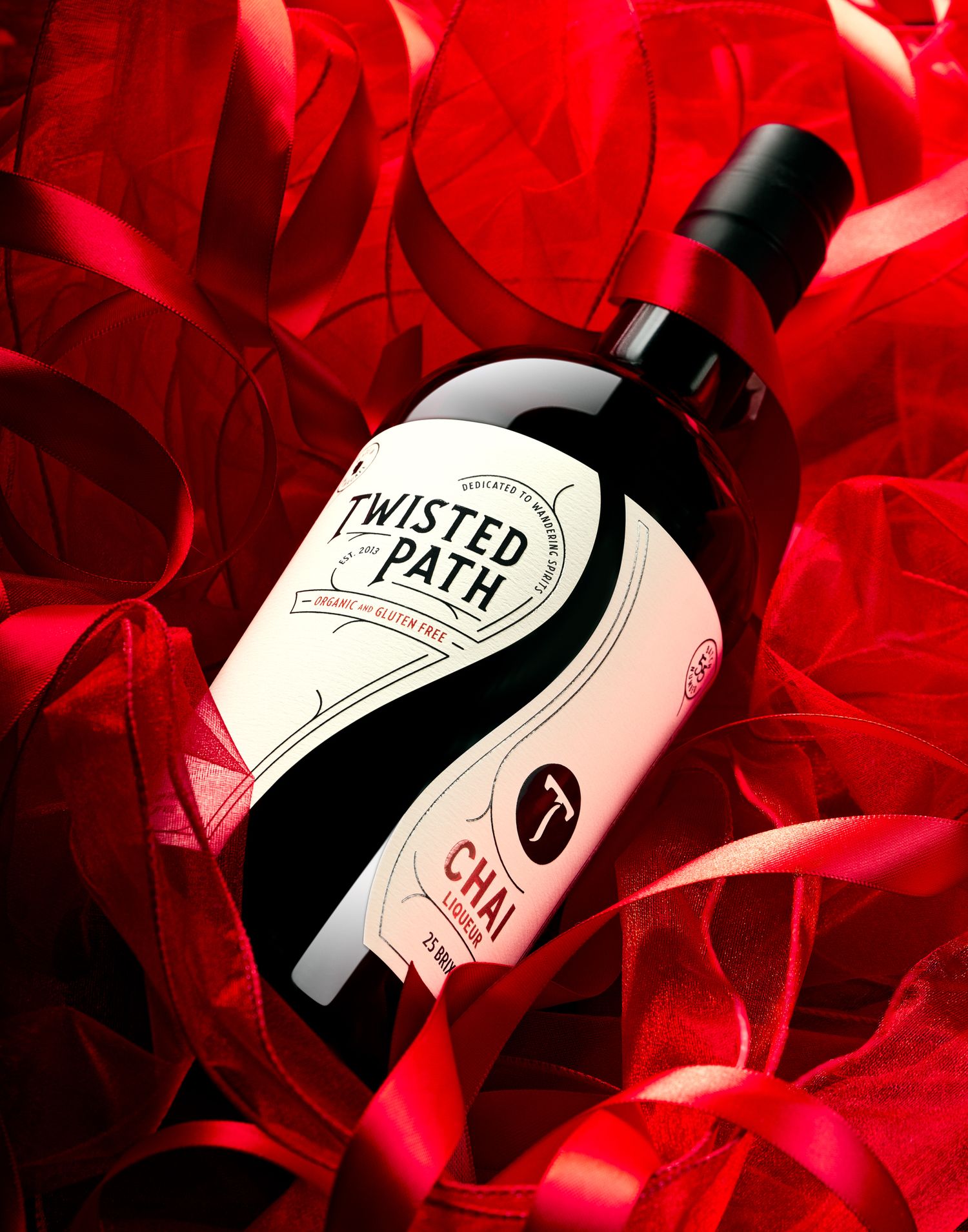 Bottle of Twisted Path spirits against dramatic red background lighting.