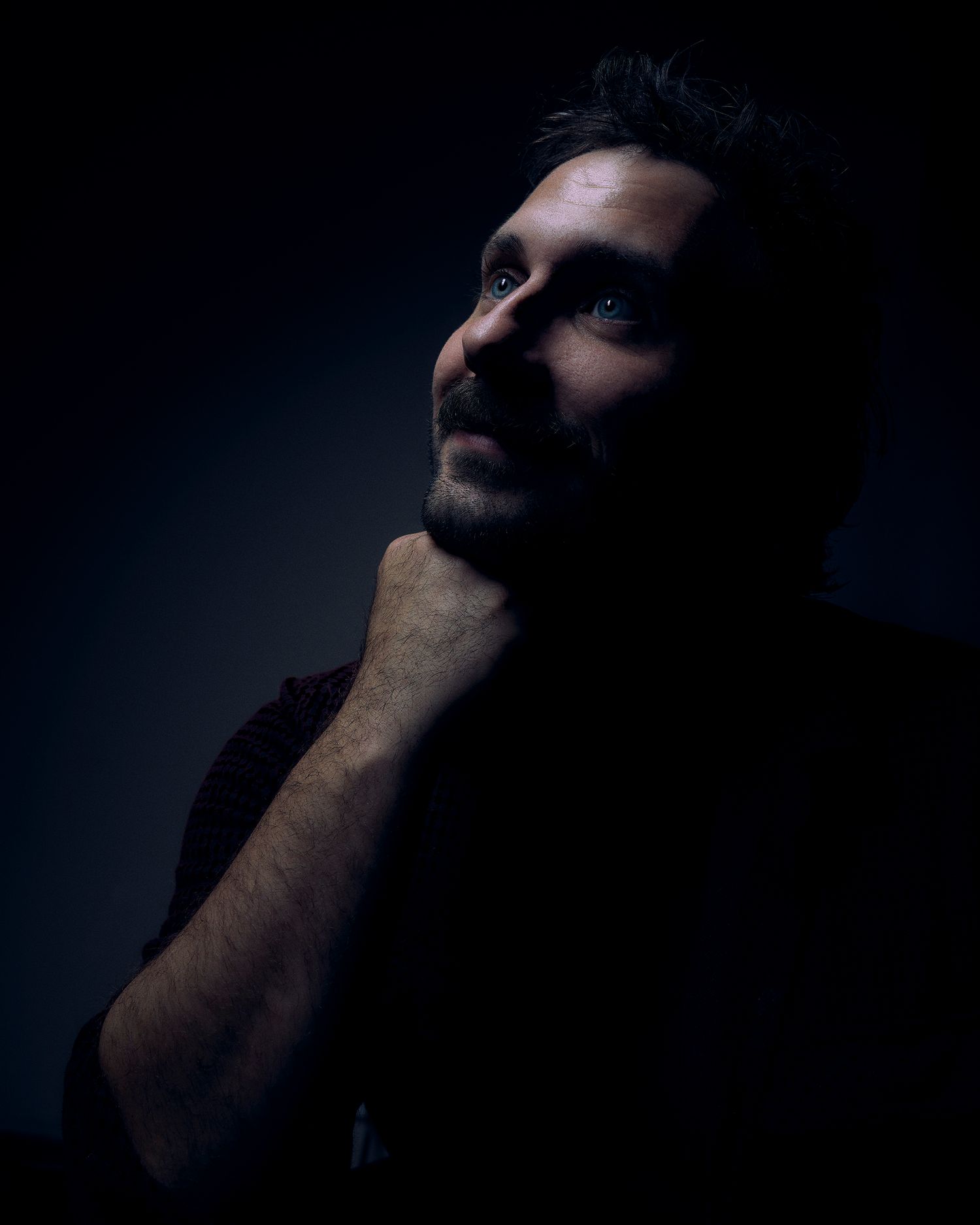 Dramatic side profile silhouette in dark moody lighting.