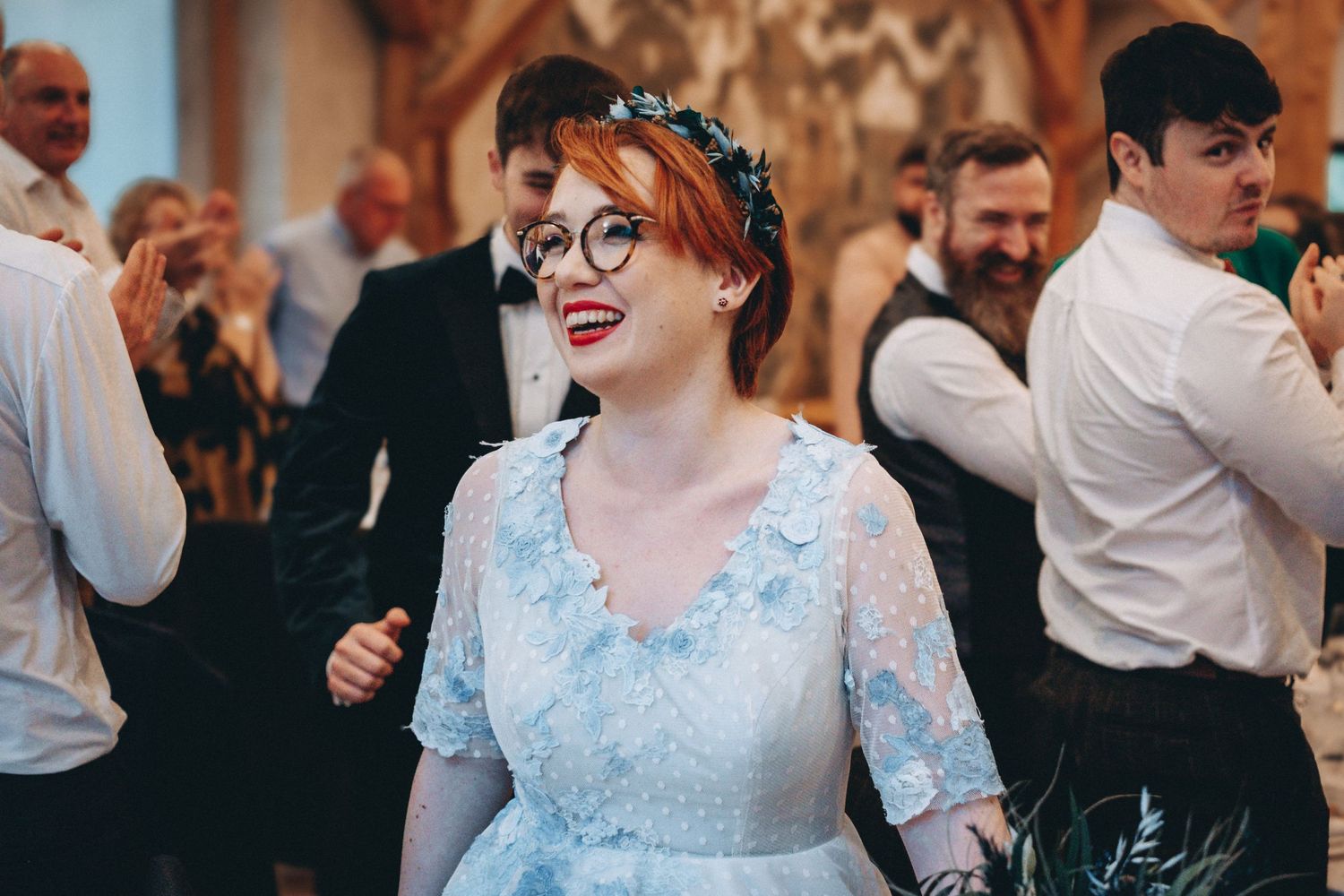 Dancing and celebration at an indoor wedding reception with guests in formal attire.