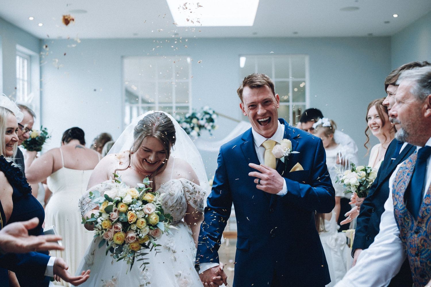 Celebratory moment during wedding ceremony with confetti flying through the air.
