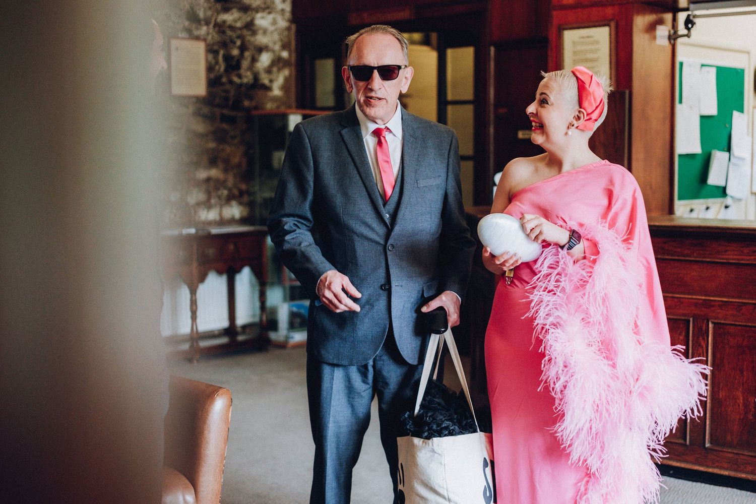 Wedding party members walking together in formal attire with pink accents.