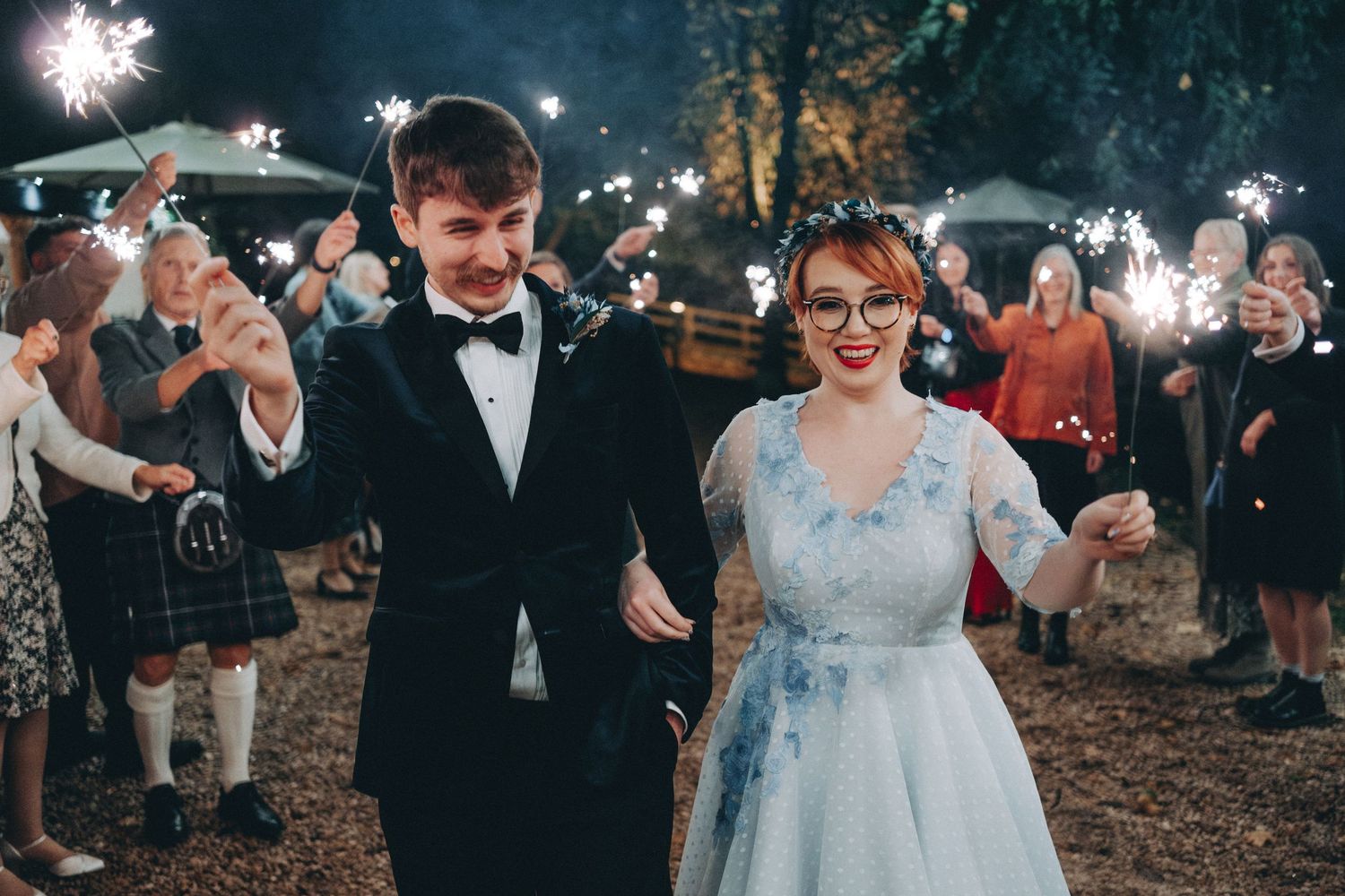 Evening wedding celebration with sparklers creating magical light trails in the darkness.