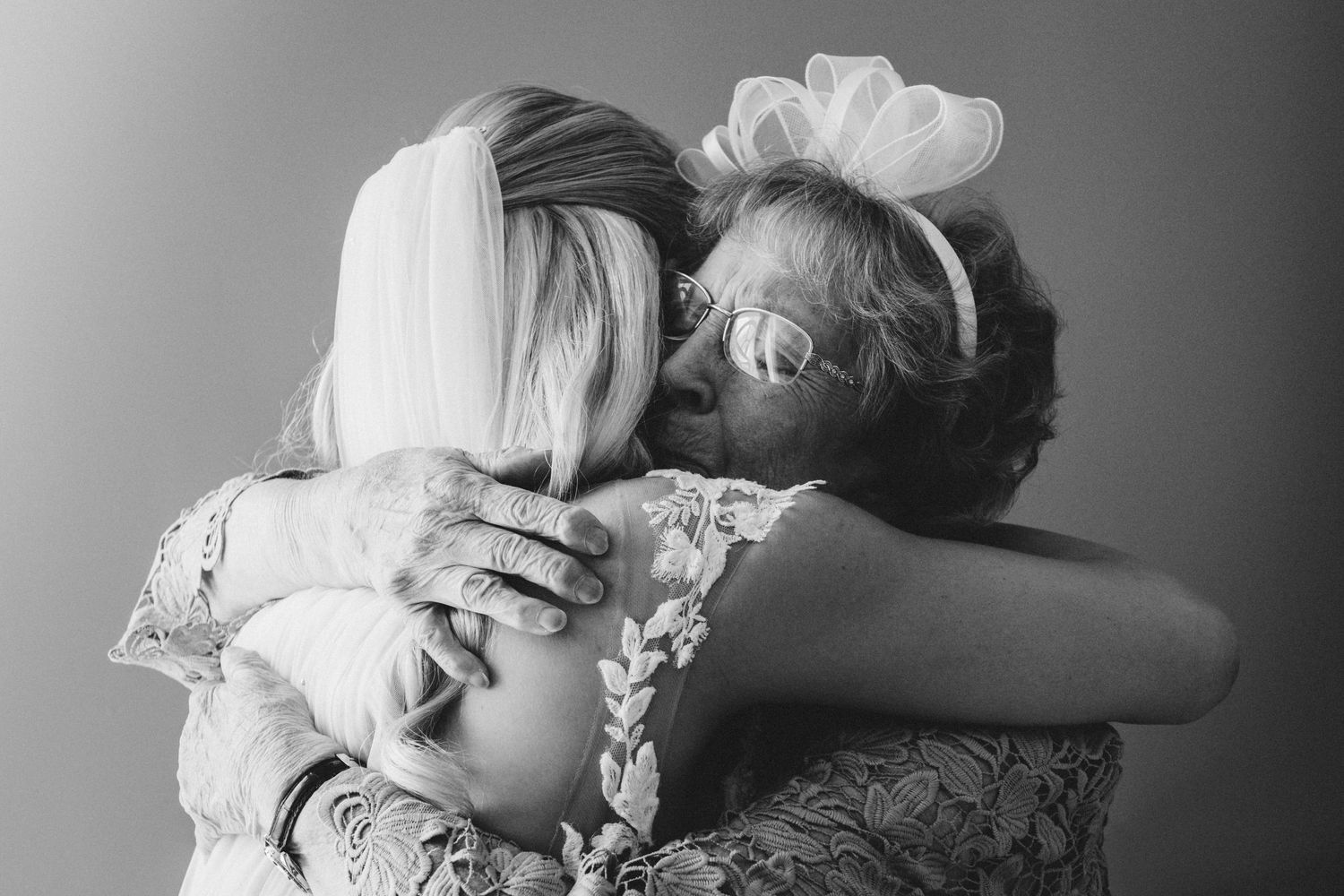 Dramatic black and white wedding photography with emotional embrace.