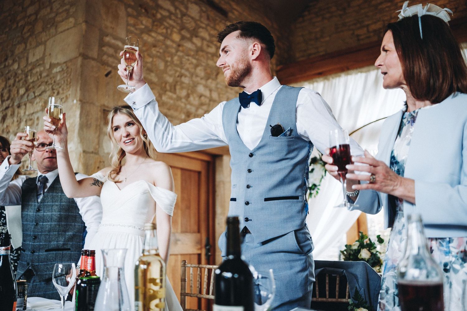 Wedding guests raise their glasses in celebration at Upcote Barn Wedding venue during a joyful toast moment.