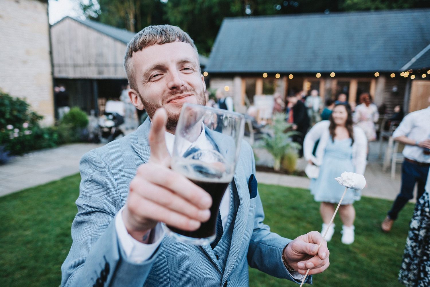 Wedding guests enjoying drinks and conversation during an outdoor reception.