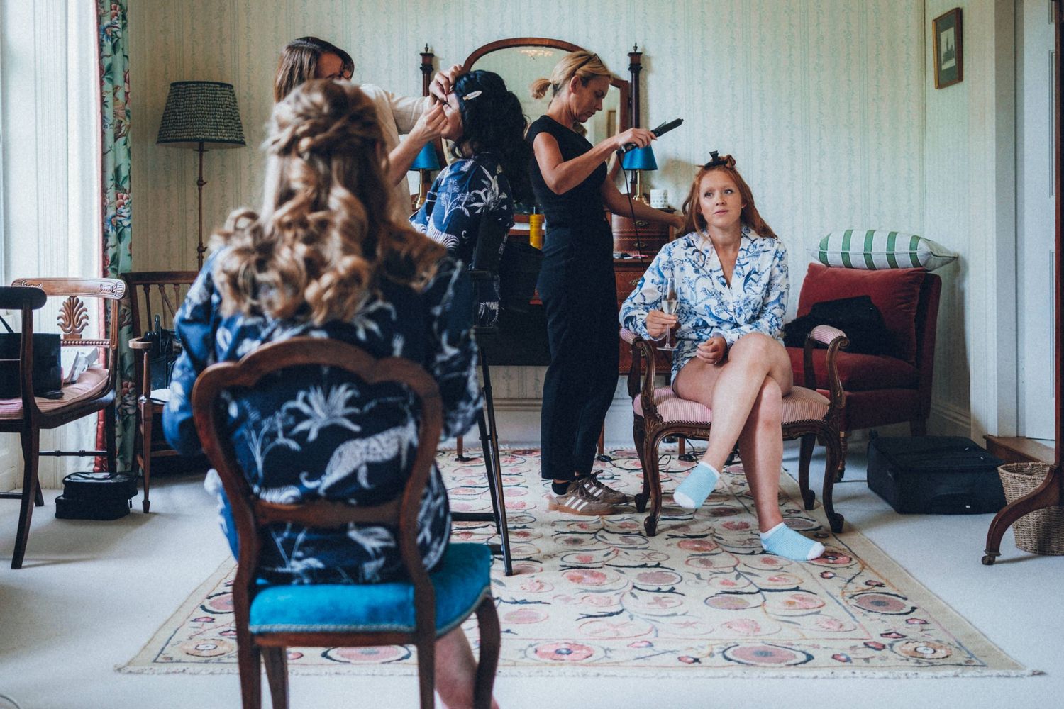 Behind-the-scenes of wedding preparations with photographers and stylists in a decorated room.