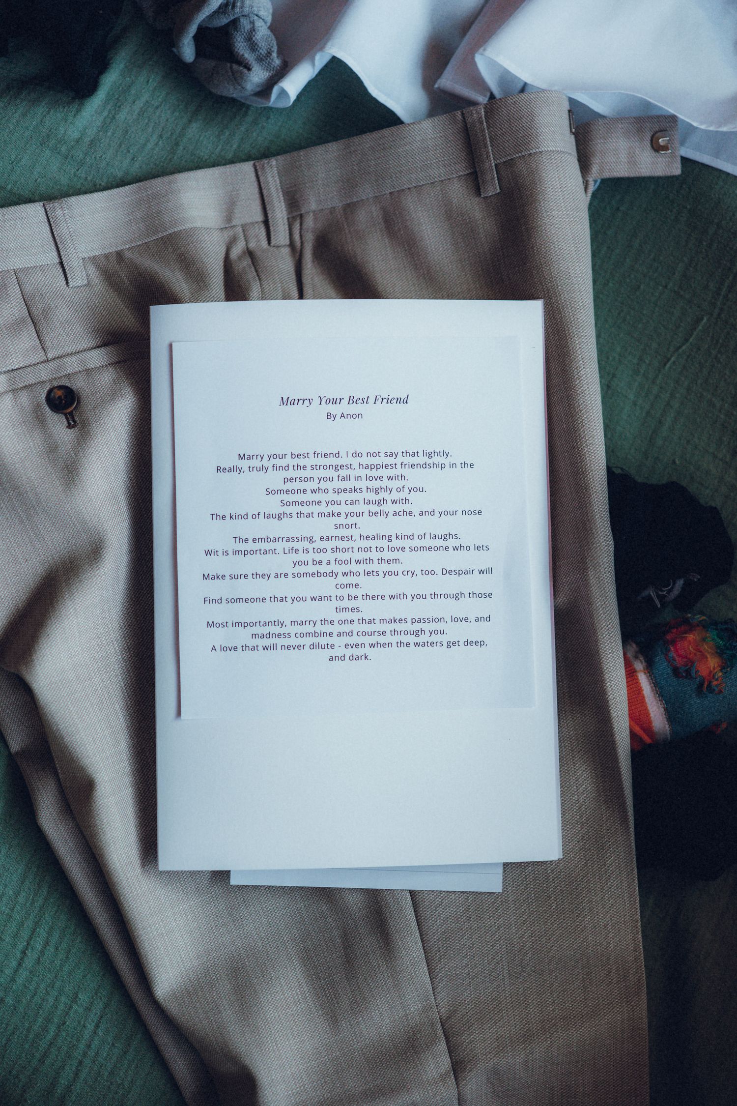 Wedding vows or poem printed on white paper laying on khaki fabric.