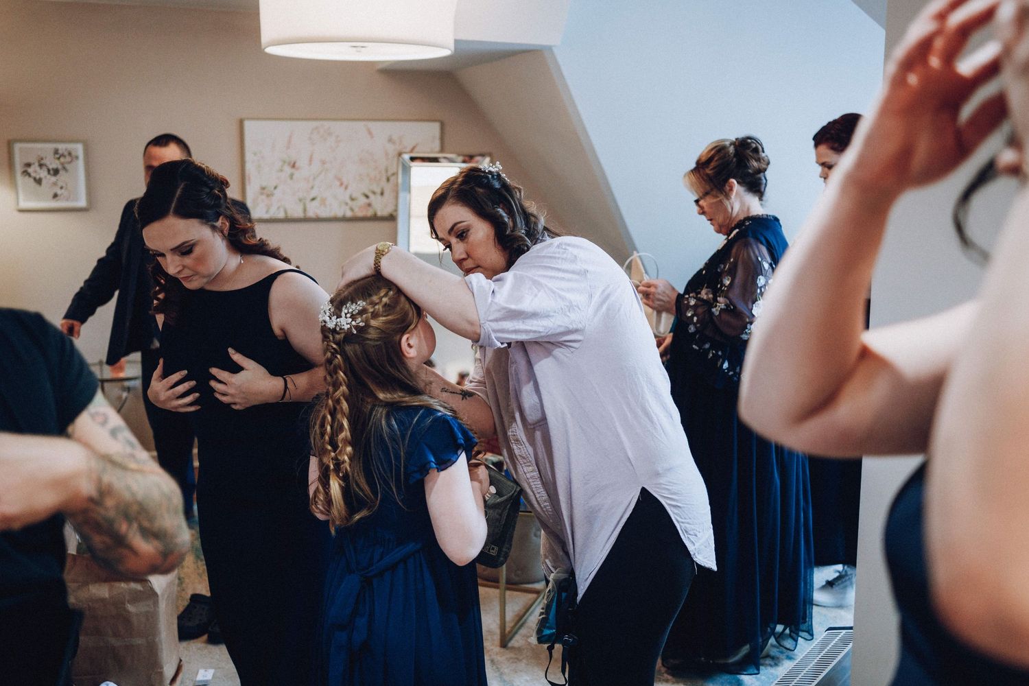 Wedding party members share emotional embraces during preparation time.