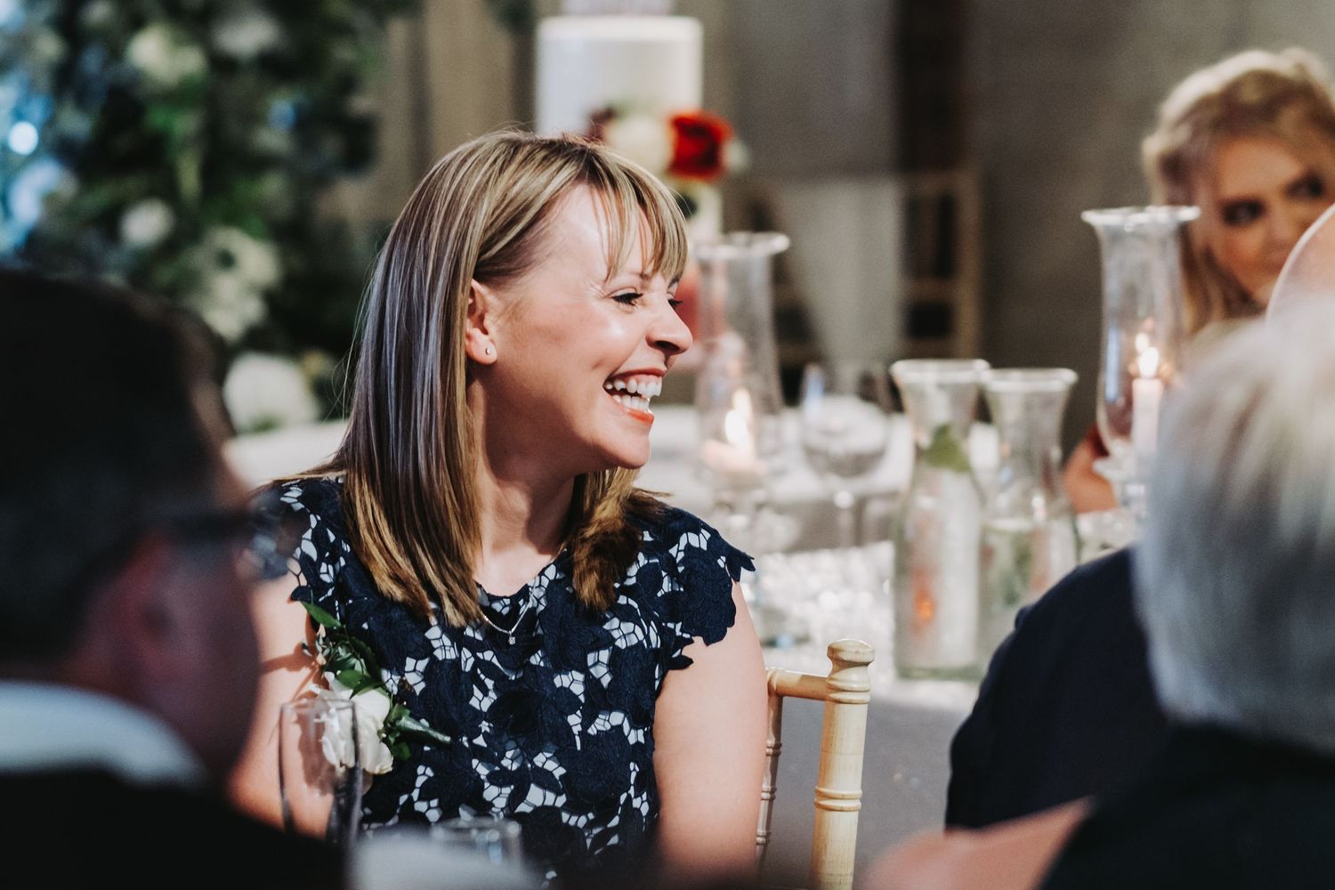 Wedding guest laughing during dinner reception festivities.