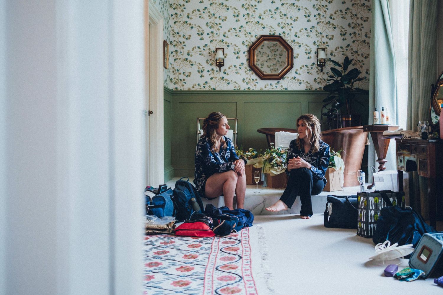 Wedding preparation scene in a vintage-styled room with floral wallpaper and casual atmosphere.