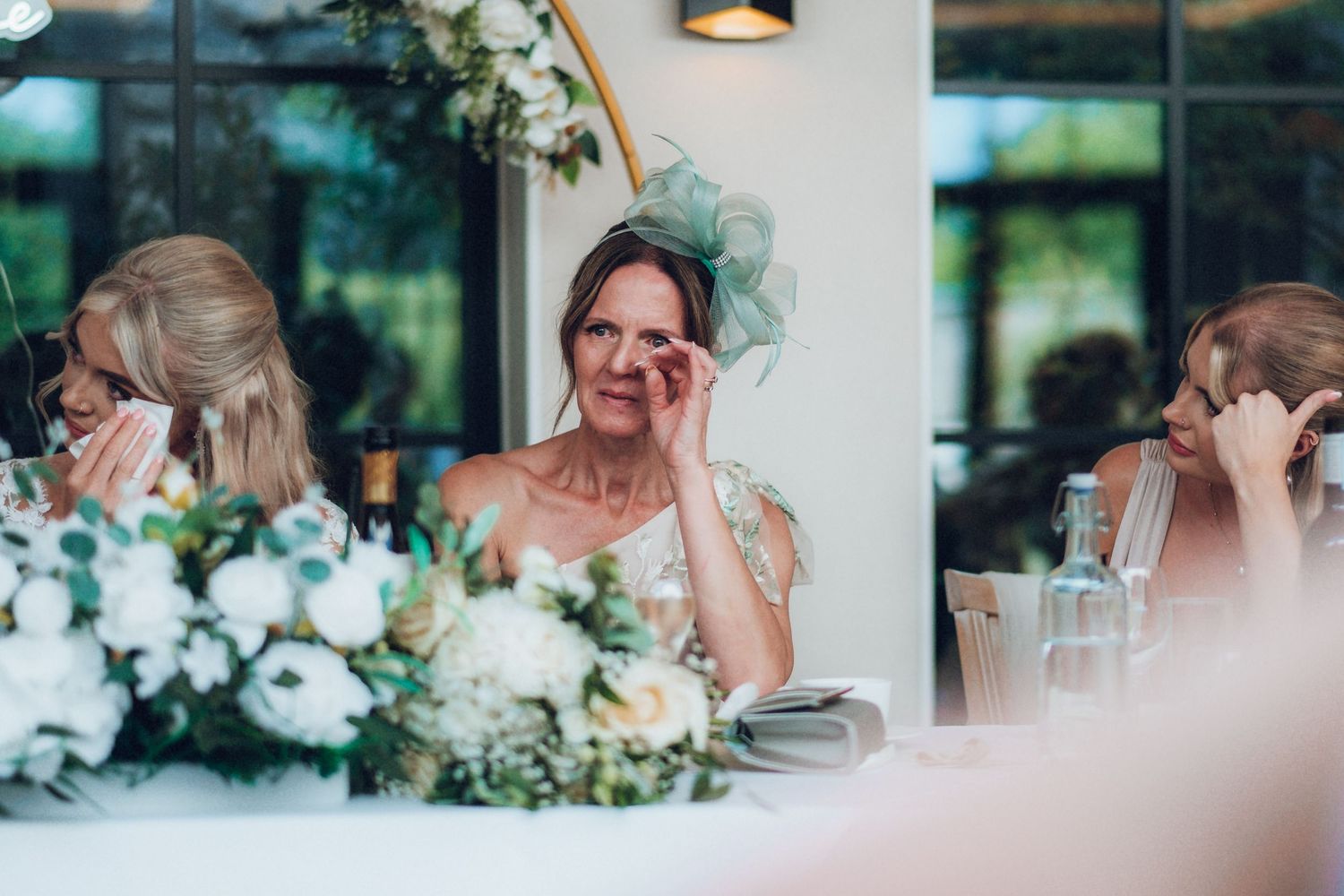 Wedding guests enjoying speeches and toasts at an elegant indoor reception.