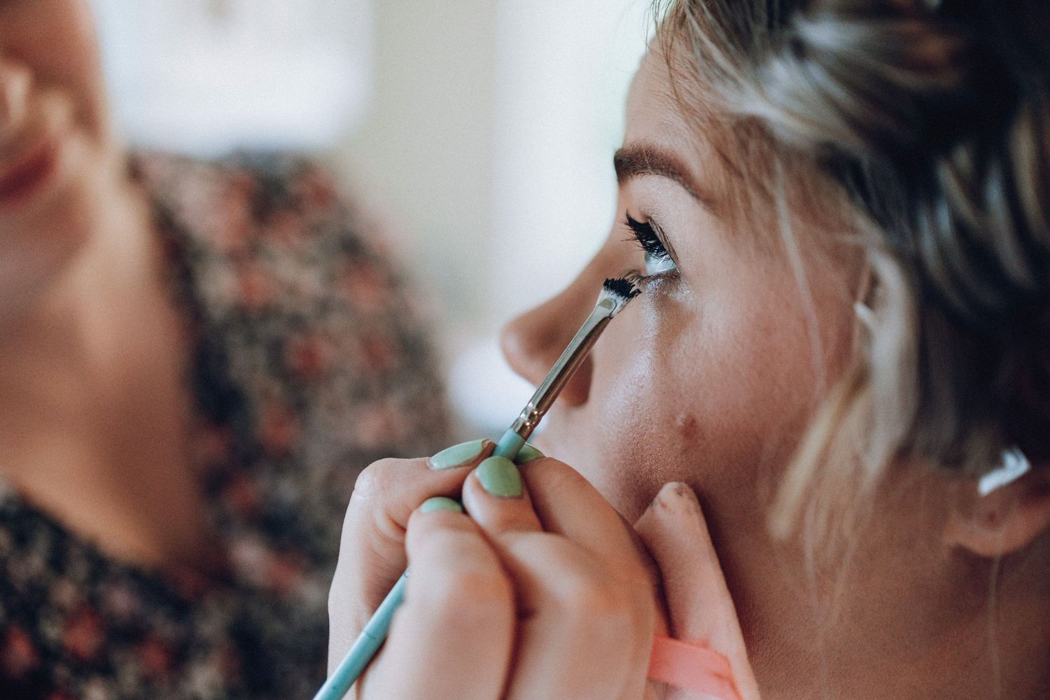 Close-up shot of someone applying eye makeup with a thin brush.