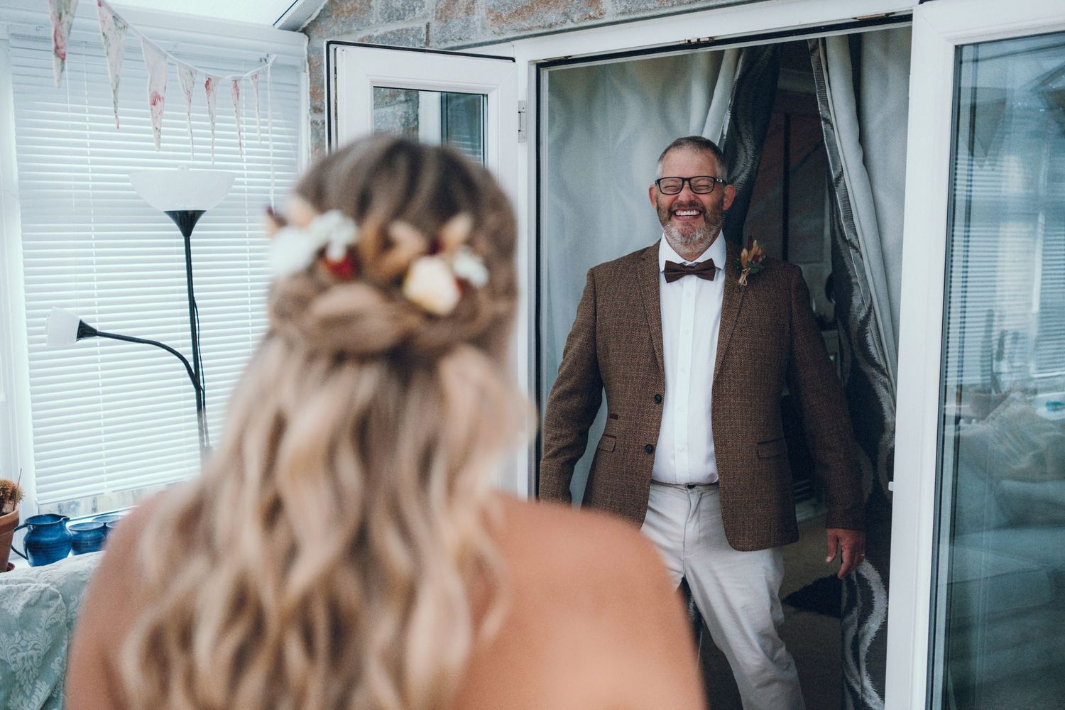 People gathered near glass doors in formal wedding attire.
