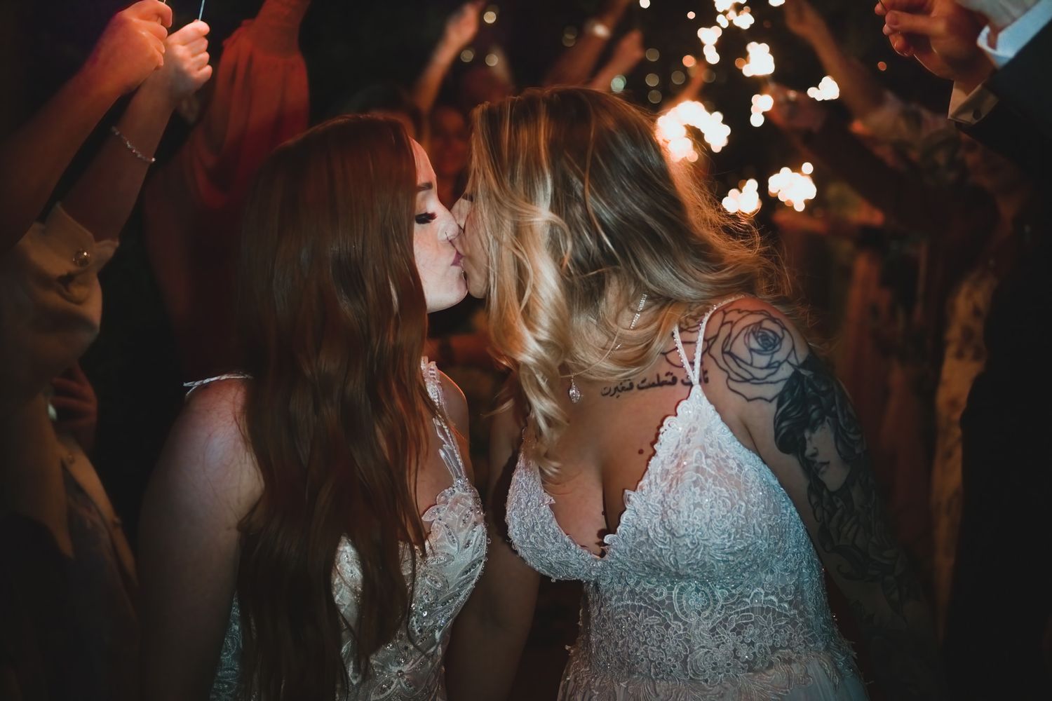 Wedding reception dance floor filled with celebrating guests under twinkling lights.