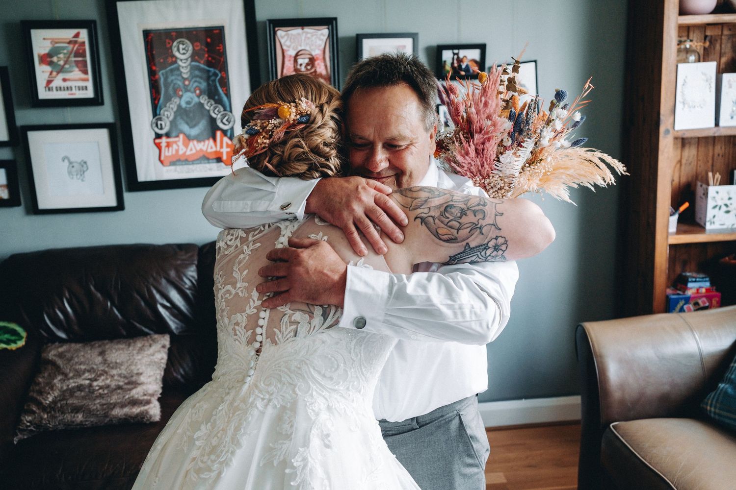 Wedding celebration moments captured in a cozy home setting with dark walls.