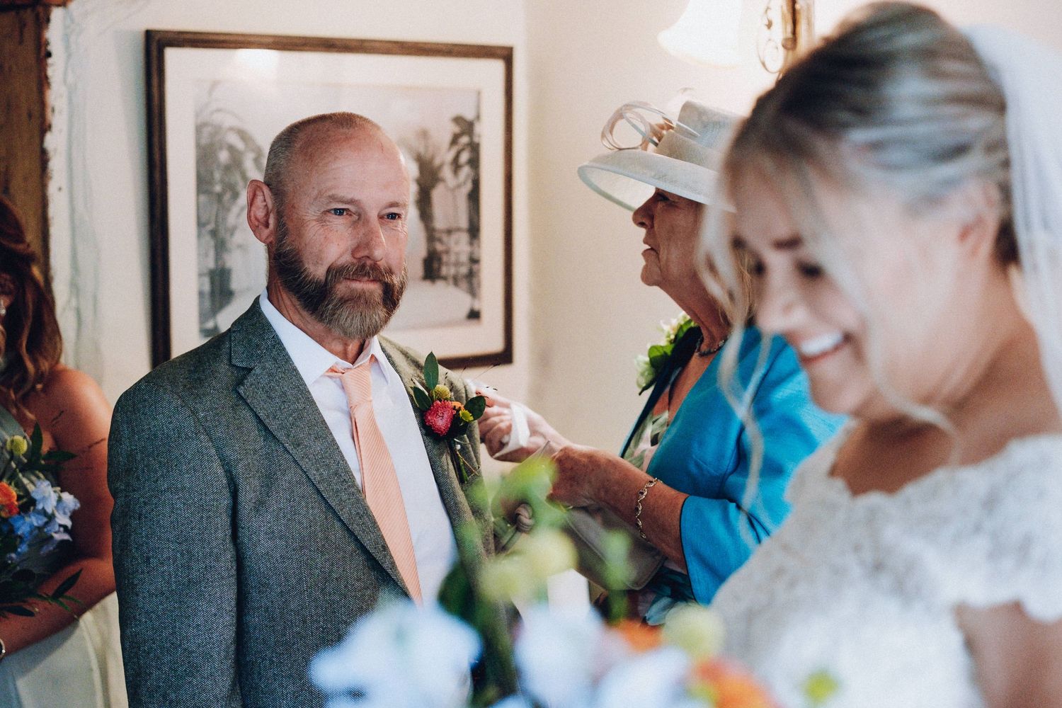 Wedding party moment captured indoors with formal attire and flowers.