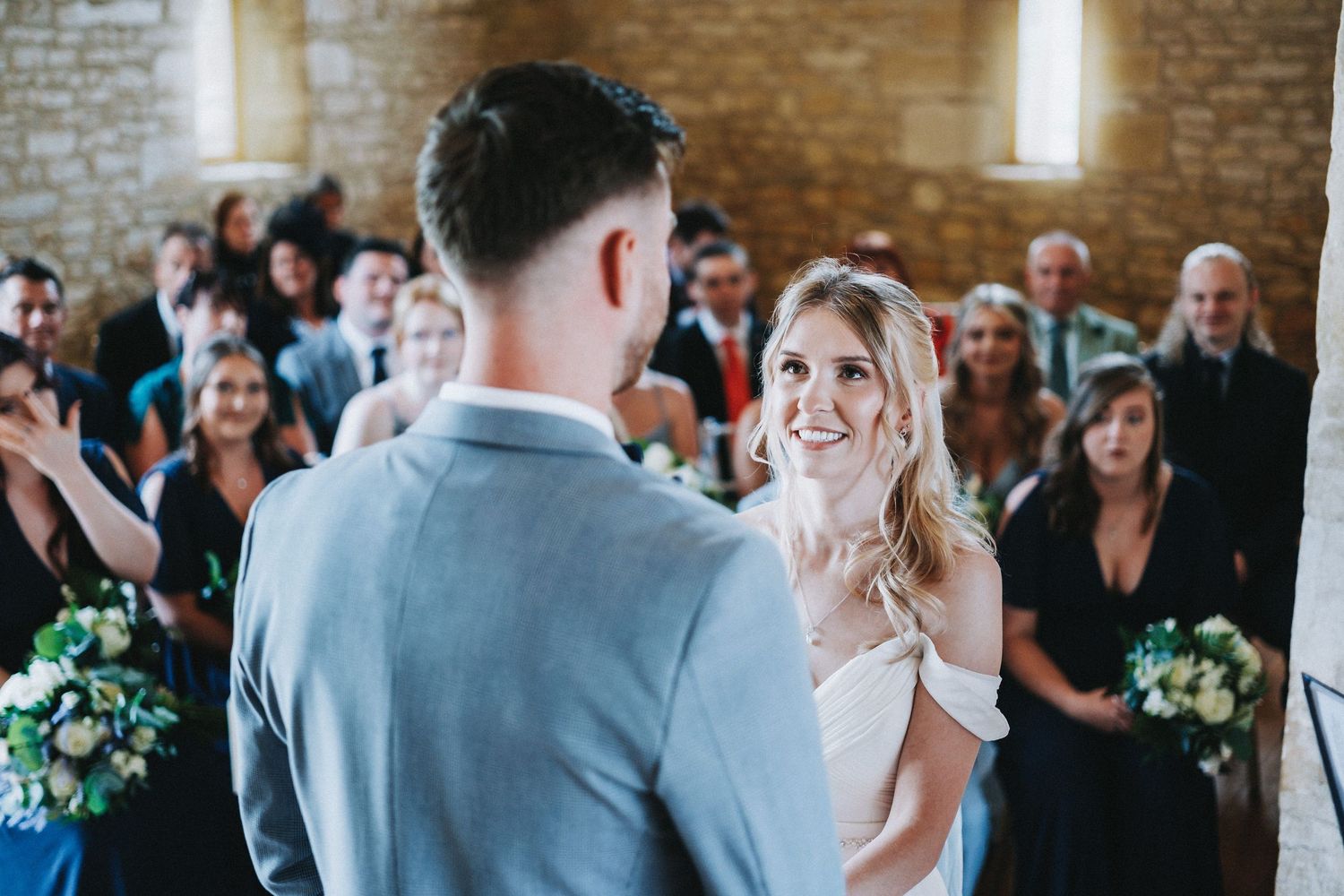 Emotional reactions during a wedding ceremony in a rustic stone-walled venue.