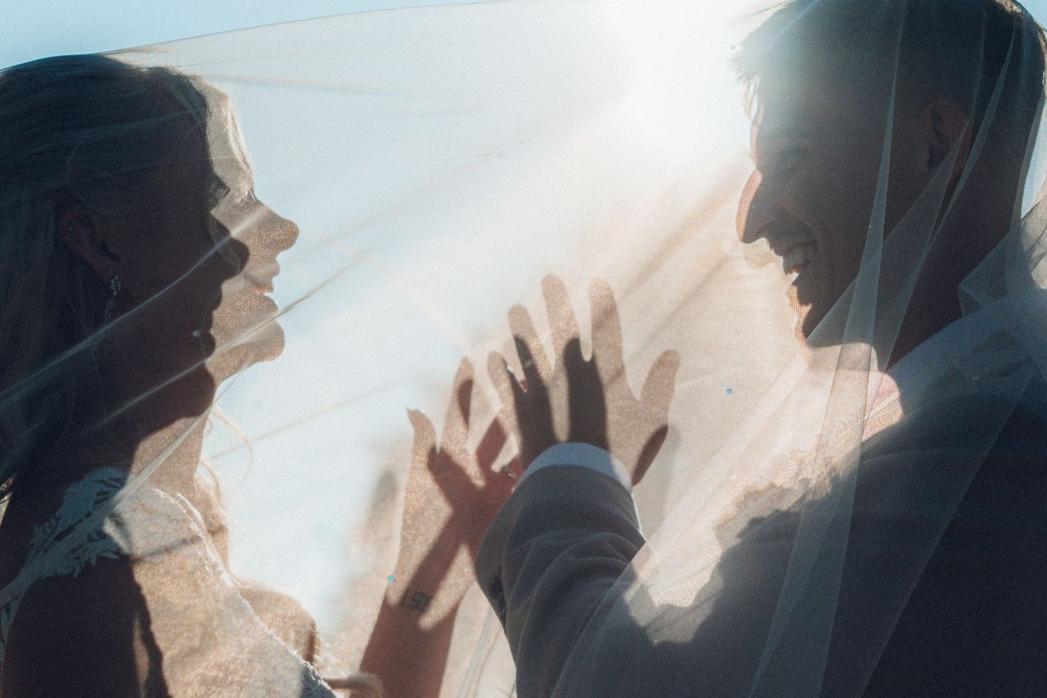 Silhouetted figures celebrate with raised arms against a bright background.