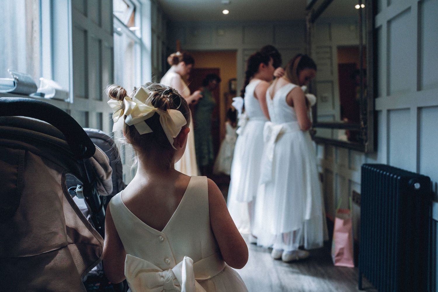 Wedding party members prepare in a bright indoor space before the ceremony.