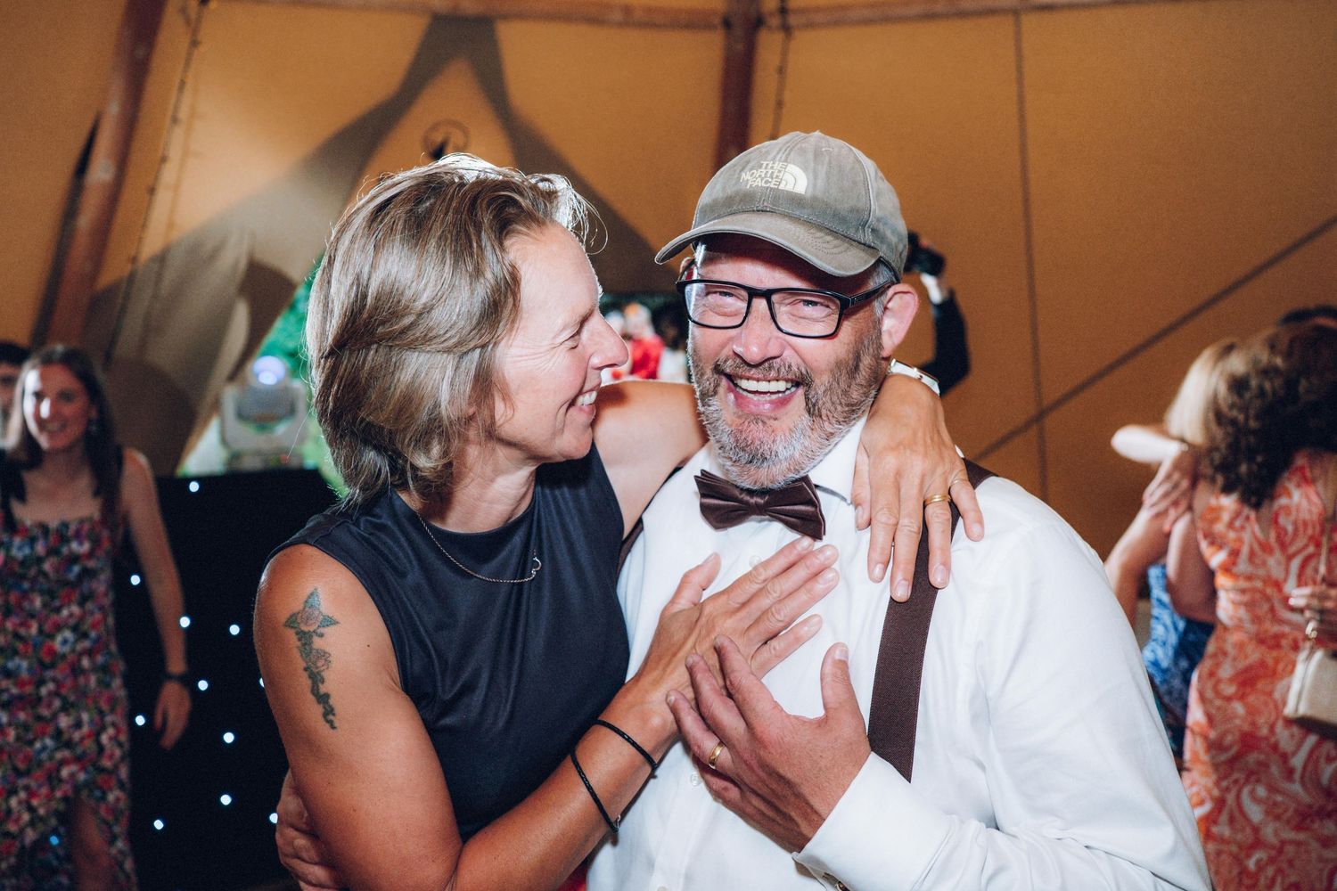 Joyful dancing and embracing at a lively wedding reception.