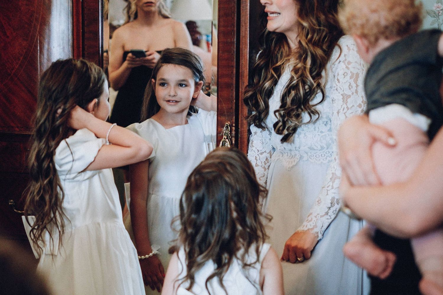 Wedding party members sharing candid moments in an elegant indoor setting.