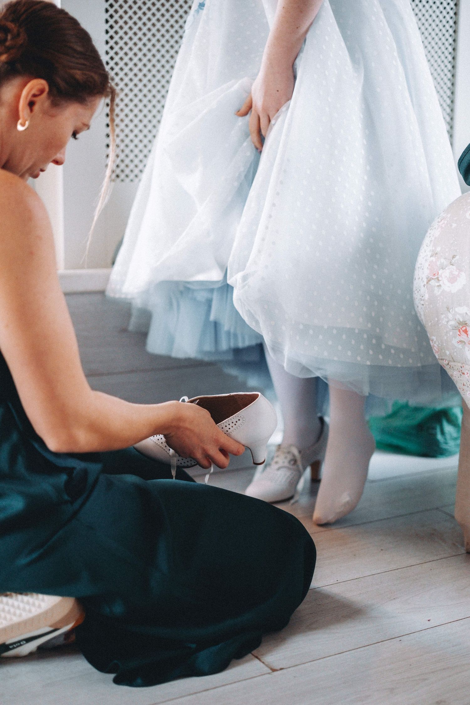 Someone helps adjust a bowtie during wedding preparations.