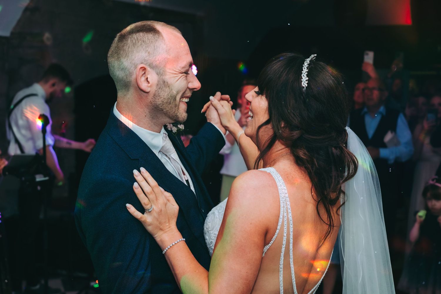 Energetic wedding reception dance party with guests singing and celebrating.