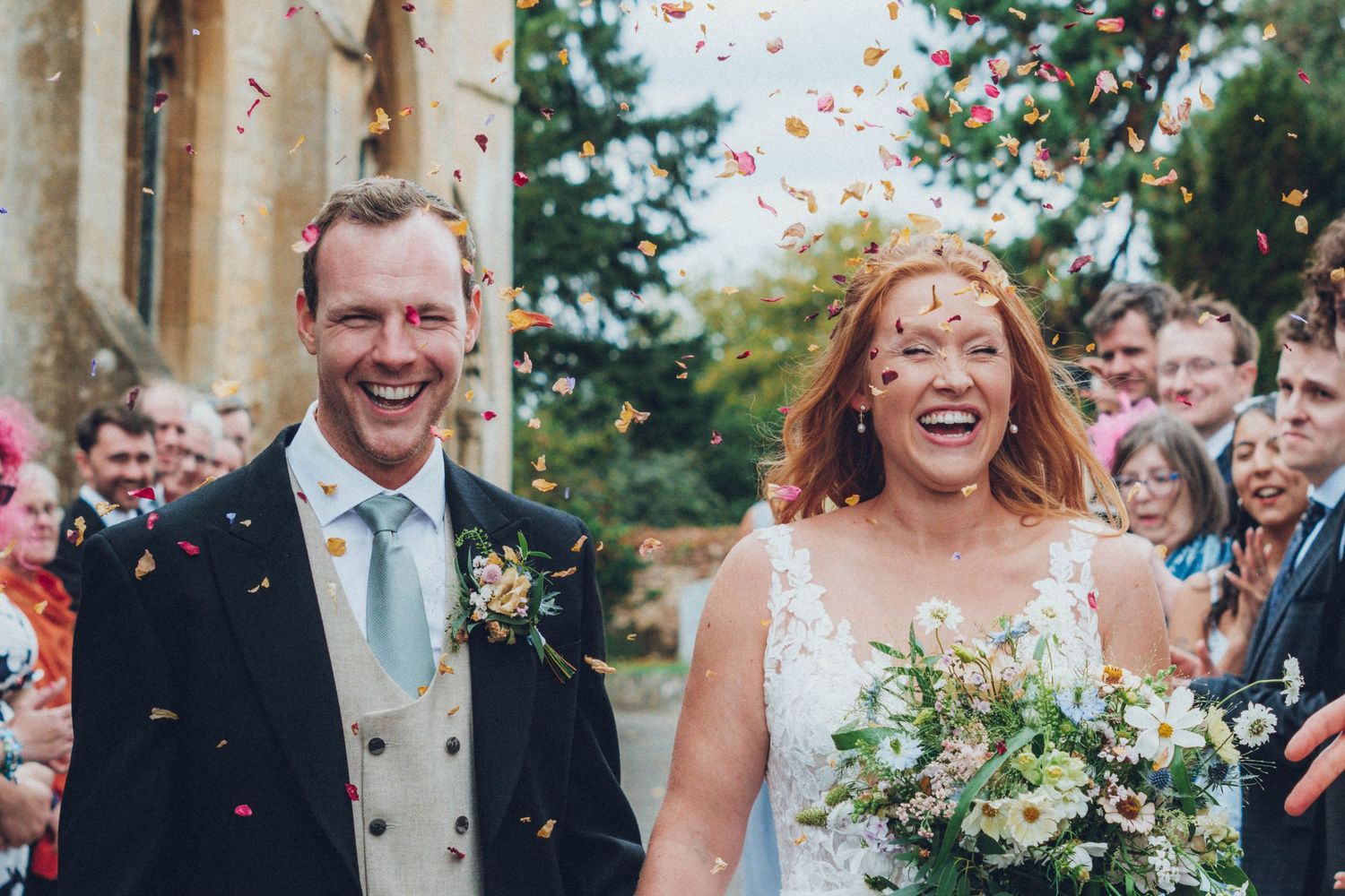 Wedding guests shower the happy couple with confetti on their special day.