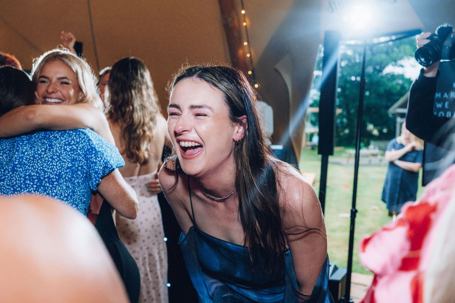 Lively dance party with guests celebrating at an indoor wedding reception.