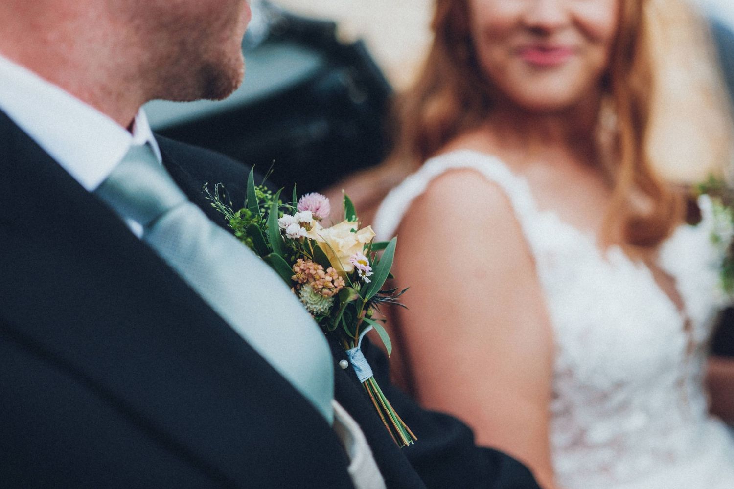 Wedding party members smile and celebrate during outdoor ceremony.