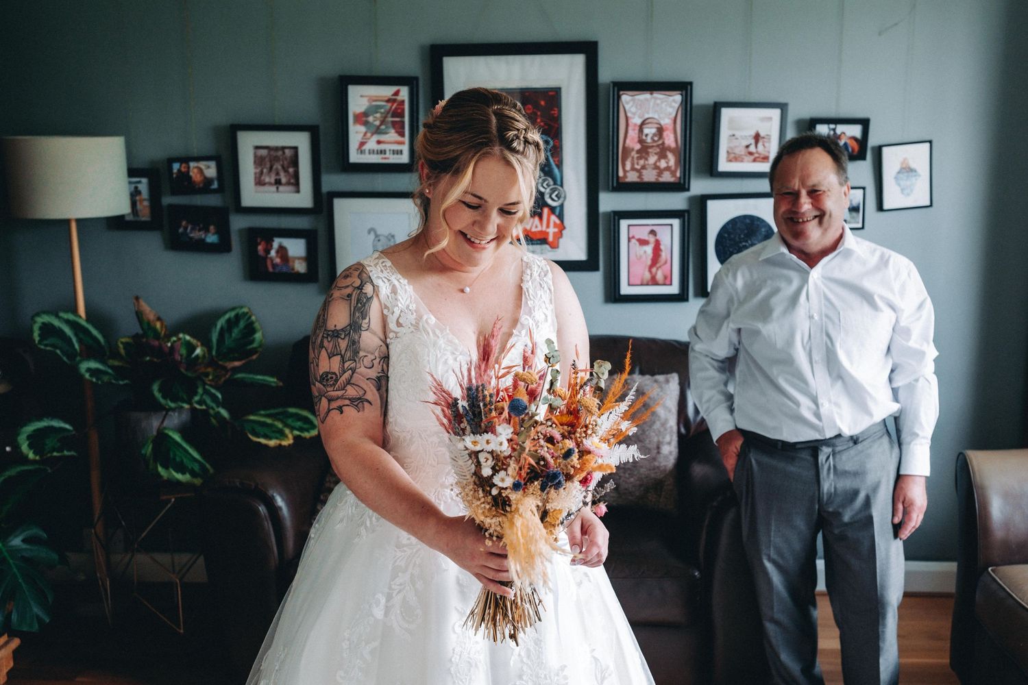 Kate in her wedding dress with dad looking very proud. Kates late mum watching over her in the photographs behind her.