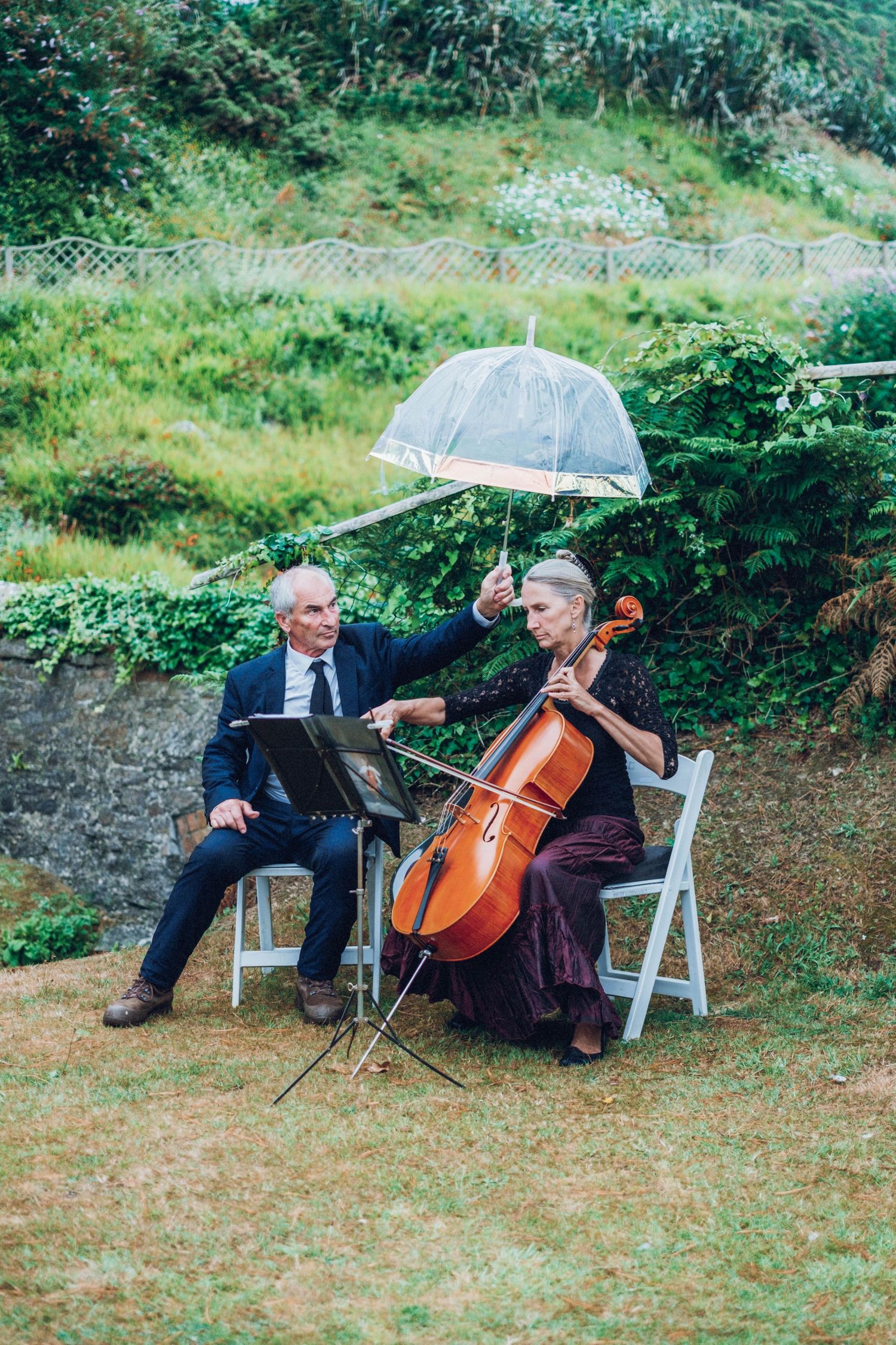Musicians playing cello during an outdoor wedding ceremony.